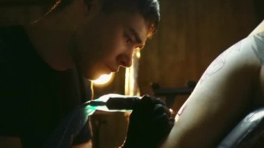 Plastik film aletleriyle kaplı dövmeci portresi. Sanatçılar dükkanda çalışır..