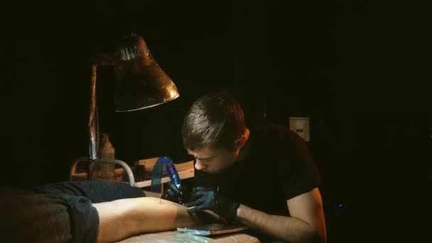 Modello di riempimento tattooista del tatuaggio sullo stinco dei clienti. Protezione pellicola plastica. — Video Stock