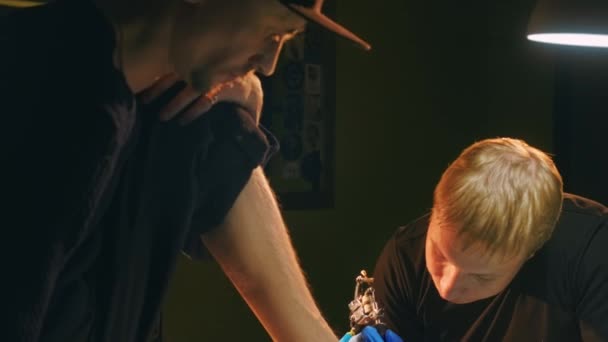 Patrón de tatuaje de pies, cara de artista tatuador enfocado con máquina de aguja de bobina. — Vídeo de stock