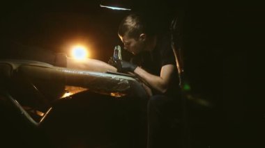 Dövmeci müşterilerin bacağında dövme izi var. Plastik film koruması.