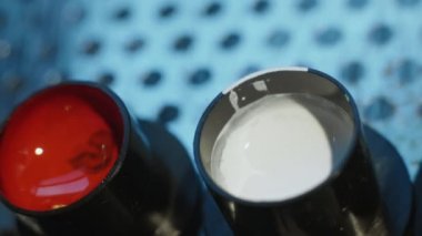 Dövme sanatçısı magnum iğne çubuk makinesinde beyaz renk sıvı boya mürekkebi dolduruyor.