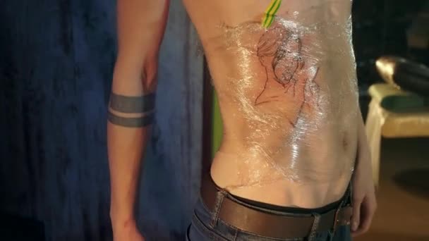 Färsk gjort flicka ansikte tatuering på kunder revben bur. Tatuerare konstnär studio arbete. — Stockvideo