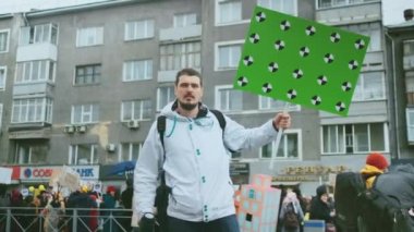 Toplantıda boş yer pankartıyla kameraya bakan siyasi protestocular.