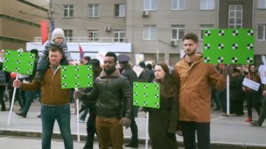 Siyasi mitingdeki çok kültürlü insanların boş kromakey pankartlarıyla.