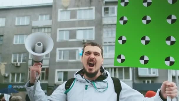 Angry screaming protest activist with bullhorn and greenscreen mockup banner. — Stock Video