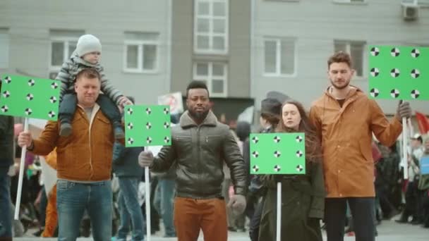 Diverse crowd of protesting people at rally with greenscreen mockup banners. — Stock Video