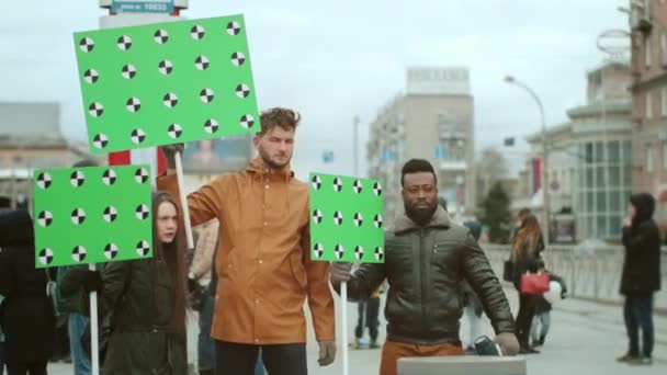 Политические активисты разных народов на митинге с зелеными макетами — стоковое видео