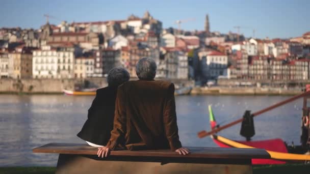 Des touristes âgés assis ensemble sur le quai de la rivière Duero. Affichage de l'amour. — Video