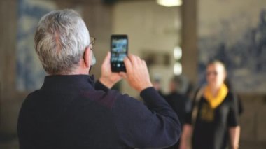 Yaşlı bir çift Sao Bento tren istasyonunda fotoğraf çekiyor..
