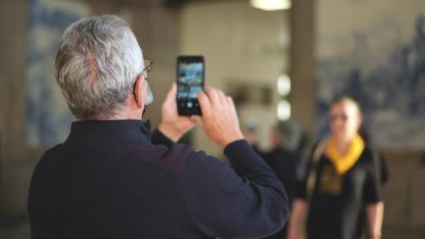 Beberapa wisatawan lansia mengambil foto telepon di dalam stasiun kereta api Sao Bento. — Stok Video