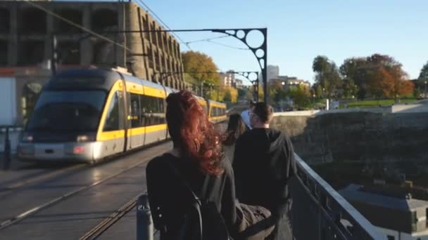 Ginger chevelu dame touristique promenades sur Ponte de Dom Luis I dans la foule des voyageurs. — Video