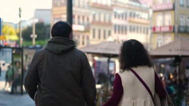 Avrupa 'da turizm şehrinin sokaklarında yürüyen bir çift Avrupalı aile.