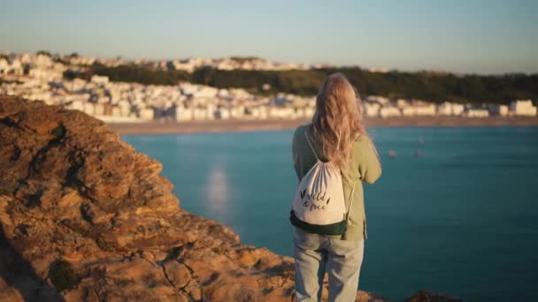 Femme voyageuse sur les rochers du Fort de Sao Miguel Arcanjo, ville de Nazare, Portugal. — Video