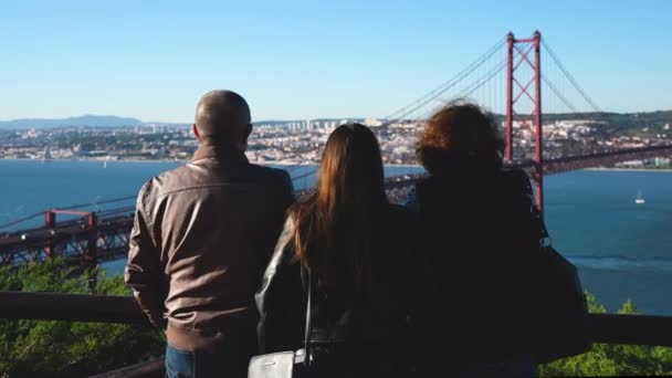 Traditionel fuld familie. Datter med forældre på bro 25 de Abril vartegn. – Stock-video