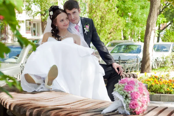 Nyligen gift par på en bänk i parken — Stockfoto