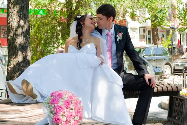 Couple nouvellement marié sur un banc dans le parc — Photo