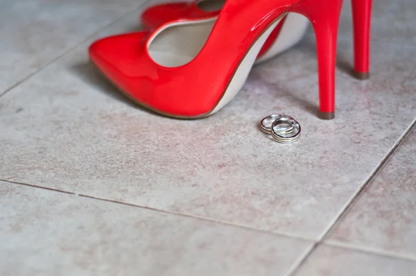 Red shoes and wedding rings — Stock Photo, Image