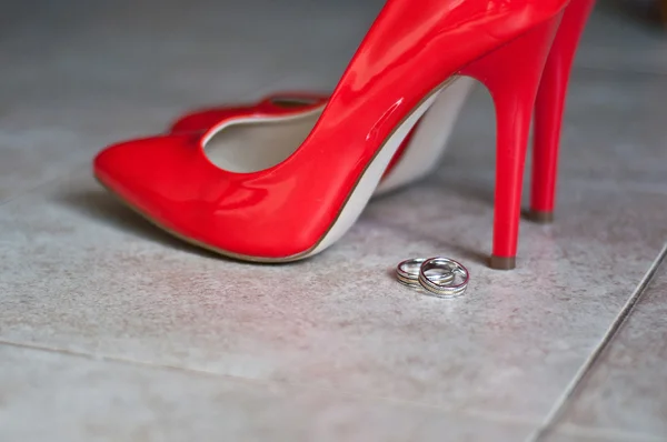 Red shoes and wedding rings — Stock Photo, Image