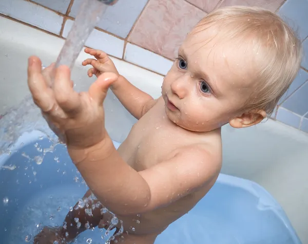 Bebê tentar tocar a água — Fotografia de Stock