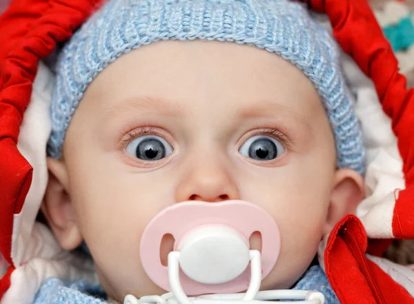 Baby with dummy, looks funny — Stock Photo, Image