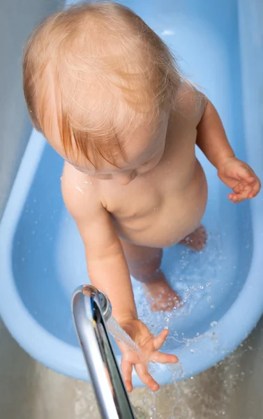 Niño trata de tocar el agua — Foto de Stock