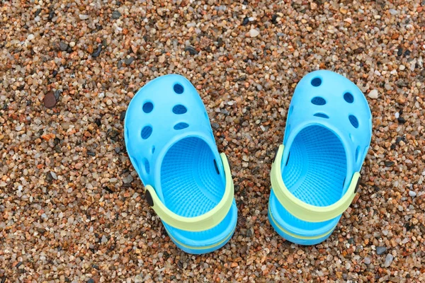 Blauwe sandalen slippers op het zand — Stockfoto