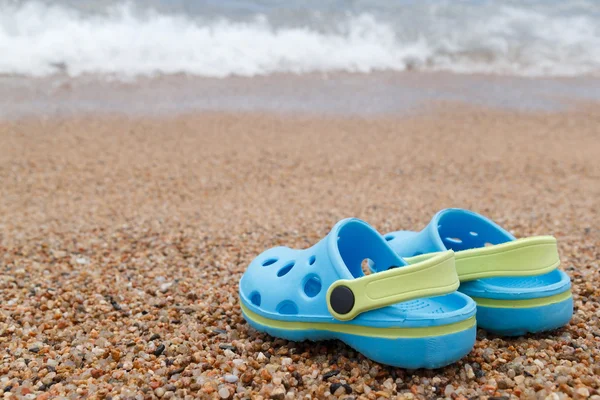 Blauwe sandalen slipper op het zand — Stockfoto