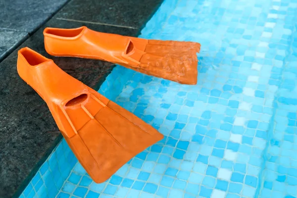 Pantoufles en caoutchouc orange dans la piscine — Photo