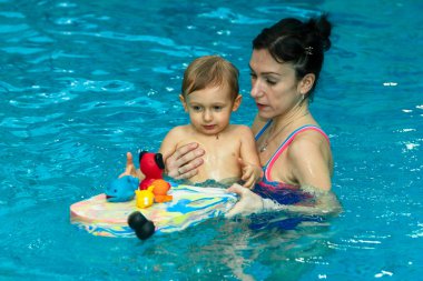 Anne bebek yüzmeyi öğretiyor