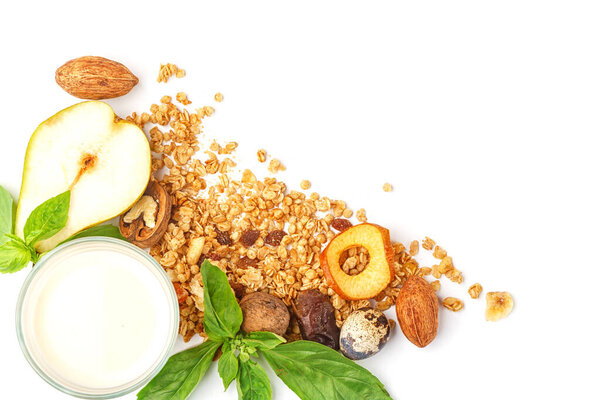 A glass of milk and muesli with fruits and herbs on a white background. Isolated.