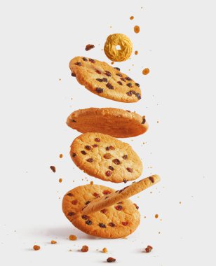 Çikolatalı Amerikan kurabiyeleri, çikolata parçacıkları ve beyaz ahşap masada kuru üzümler. Üst manzara, düz uzanma