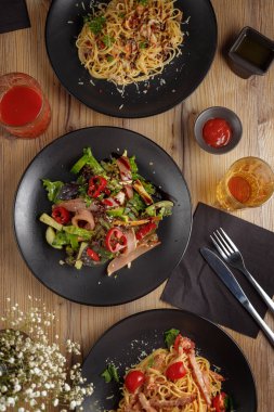 Geleneksel İtalyan makarna yemeği. Restoran servisi. Siyah plaka. ahşap masa.