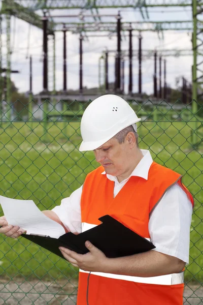 Ingenjör med mappen nära El transformatorstation — Stockfoto