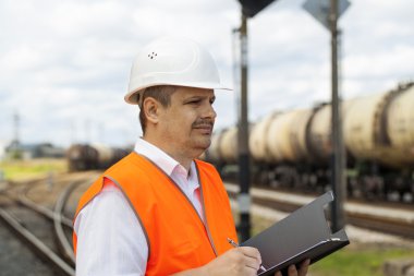 Engineer at the station near the wagons clipart