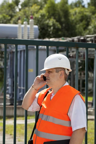 Ingenjör med telefonen nära El transformatorstation — Stockfoto