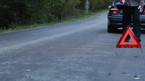 Trójkąt ostrzegawczy na drogę przed samochodem — Wideo stockowe