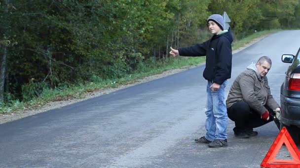 Familie op de weg proberen te stoppen met de auto voor hulp — Stockvideo