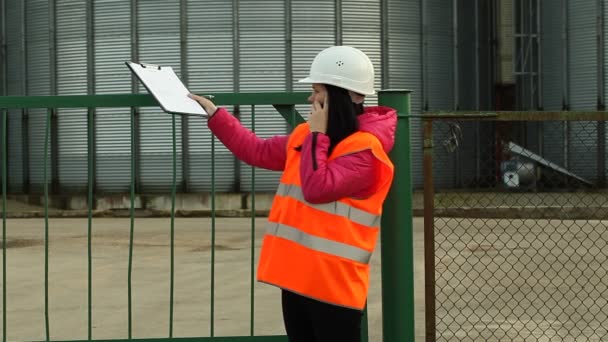 Trabajadora de fábrica hablando en un walkie-talkie — Vídeos de Stock