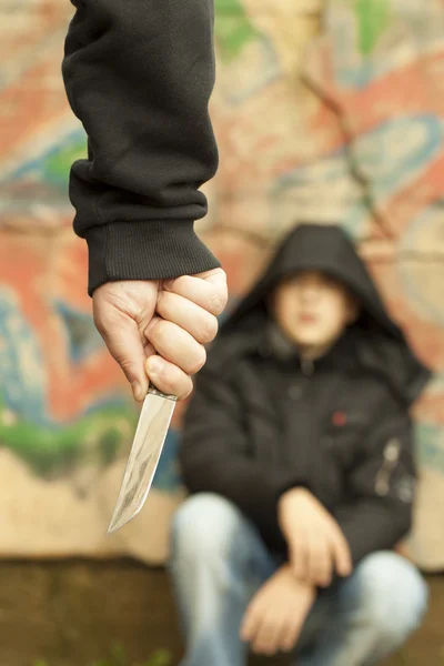 Jongen kijkt op een man met een mes — Stockfoto