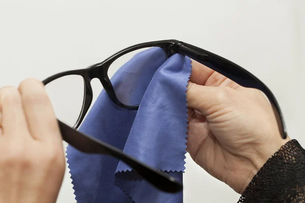 Mulher tentando limpar óculos — Fotografia de Stock