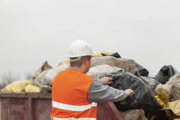 Pracownik z worków śmieci i gruzu do pojemnika — Zdjęcie stockowe