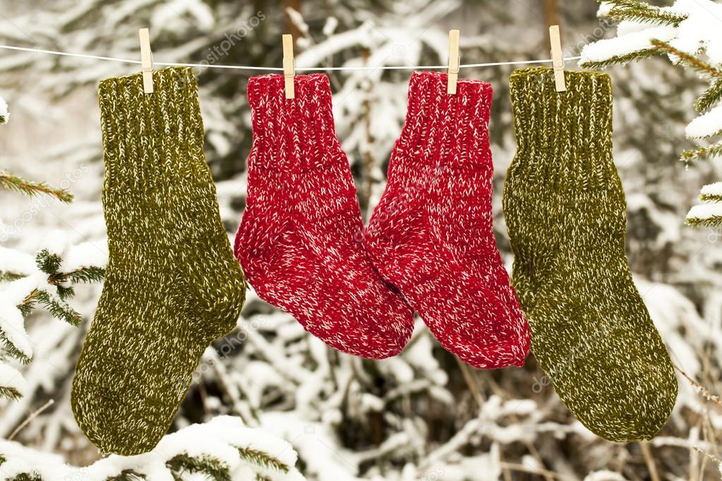 Two pairs of woolen socks hanging on rope in forest