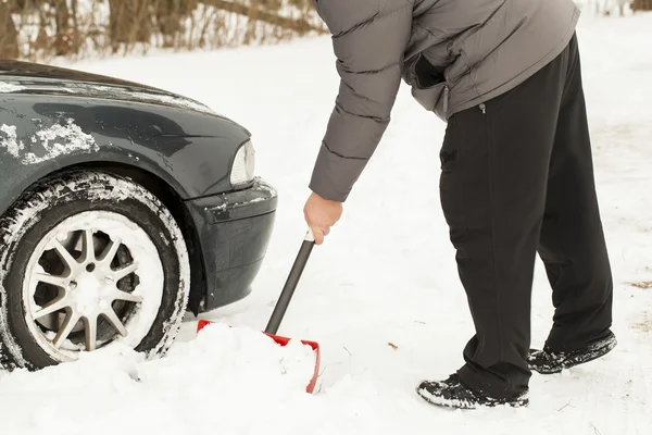 Man digging car out of the snow — Stock Photo, Image