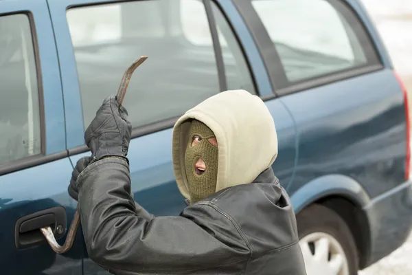 Bandyta z łomem w pobliżu drzwi samochodu — Zdjęcie stockowe