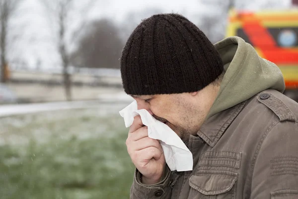 Man in sneeuwstorm in de buurt van het voertuig ambulance — Stockfoto