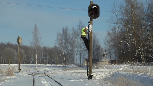 Järnvägen arbetare med mobilen på signal beacons stolpe — Stockvideo