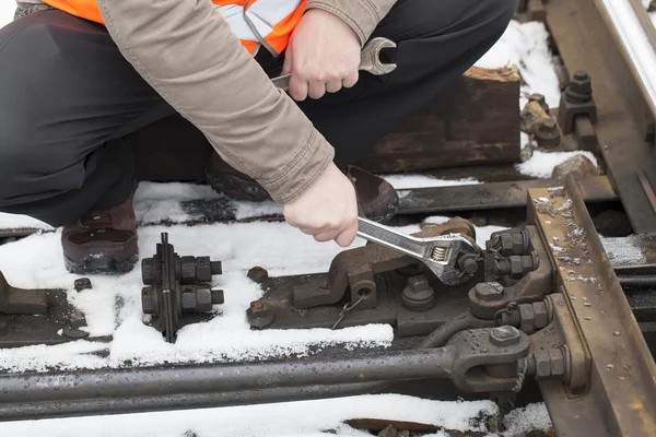 Man's hand met verstelbare sleutel op de spoorweg — Stockfoto