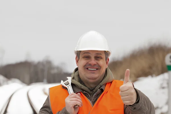 用拇指向上伸出来的手微笑着铁路工人 — 图库照片