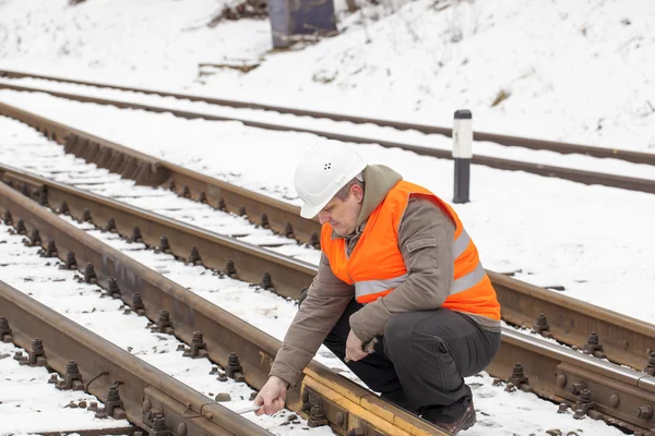 Spoorweg werknemer met verstelbare sleutel aan de spoorweg — Stockfoto