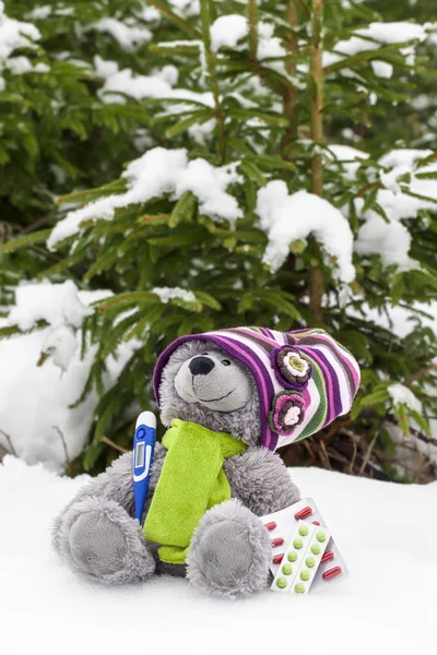 Nallebjörn med en termometer och piller i snö — Stockfoto